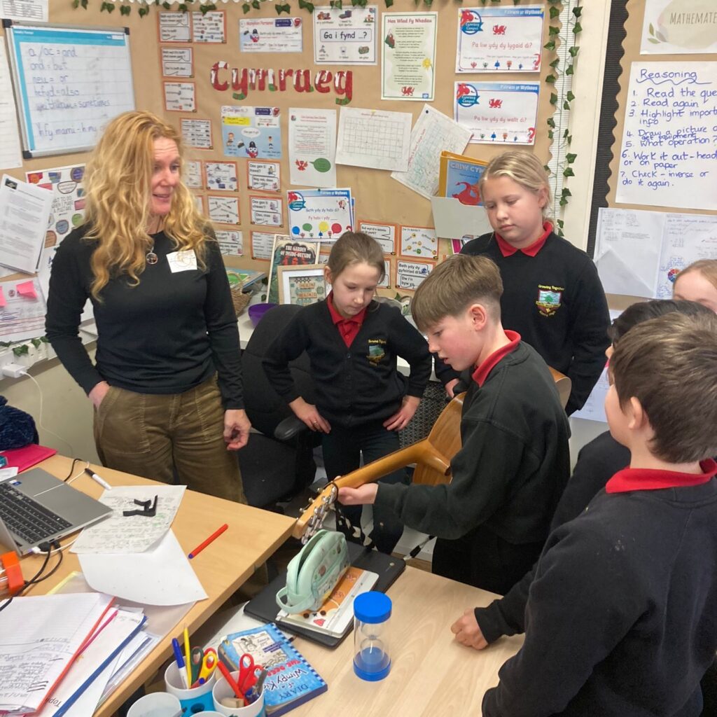 Young and Mindful during classroom mindfulness session. The pupils are listening contently as another student plays the acoustic guitar.