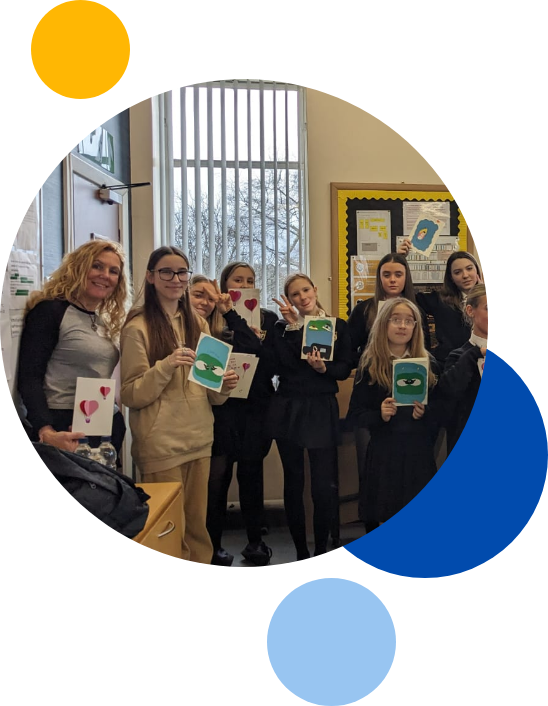 Young and Mindful in a classroom with students showing what they made during the session in a circle with blue, yellow and light blur circles surrounding them.